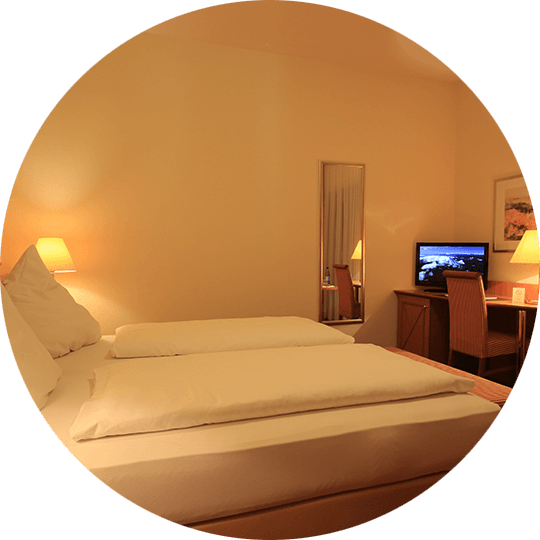 Double bed in a standard double room with TV in the Hotel Alexa Bad Mergentheim